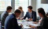 Tailored solutions – colleagues in meeting room with charts